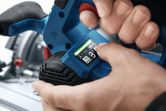 Persoon die het bedieningspaneel op een blauw elektrisch gereedschap aanpast.