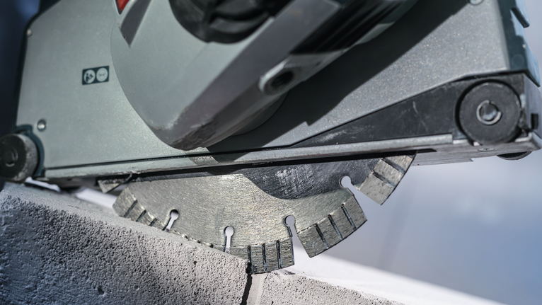 Cirkelzaag met diamantzaagblad zaagt door een betonblok.