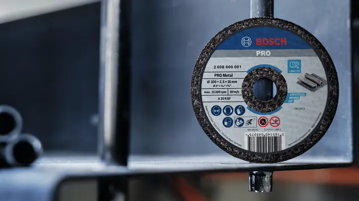 Slijpschijf bevestigd aan een metalen constructie in een industriële omgeving.