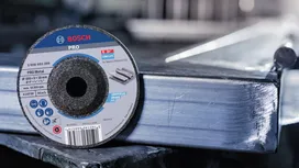 Snijschijf geplaatst op een glanzende metalen balk in een industriële werkruimte.