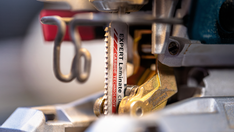 Close-up van een decoupeerzaagblad met hardmetalen tanden gemonteerd in een elektrisch gereedschap.