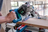 En person sager tre med en batteridrevet gjærsag, styrt av et lasernivelleringsverktøy.