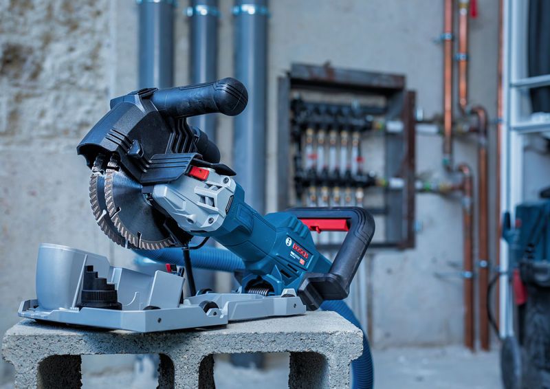 Veggfreser elektroverktøy hviler på en slaggblokk i et industrielt miljø.