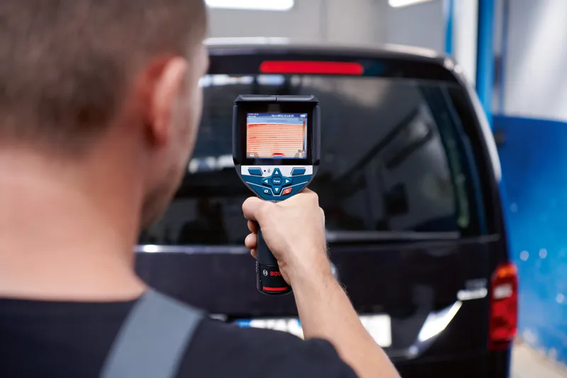 Person uses a thermo camera to scan the rear window of a vehicle.