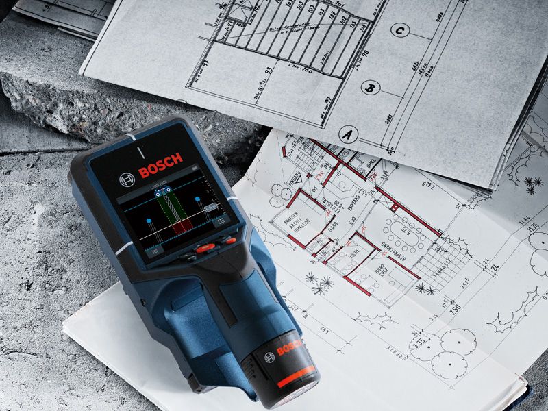 Digital detector placed on architectural blueprints for building layout analysis.