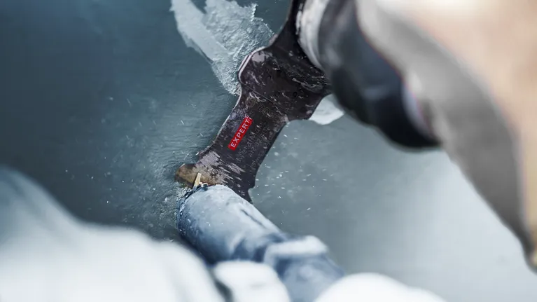 EXPERT MetalMax MAII 32 AIT Multitool Blade 70 x 32 mm Person cutting through a painted metal pipe with a reciprocating saw blade.