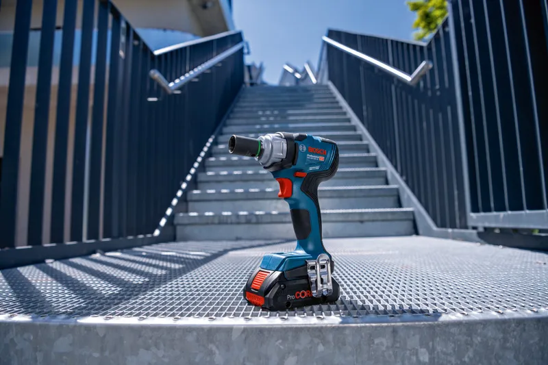 GDS 18V-330 HC Cordless power drill placed on a metal grate at the bottom of outdoor stairs.