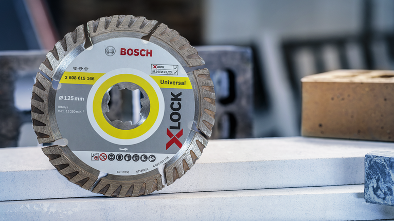 Diamond saw blade resting on stacked construction materials.