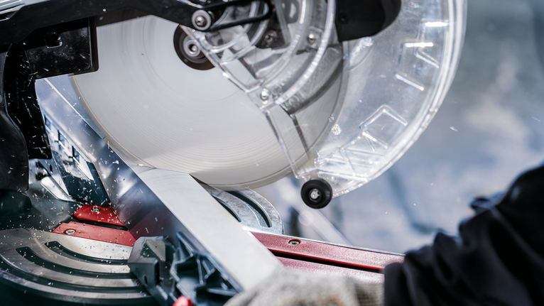 PRO Multi Material Circular Saw Blade, 305 x 3.2 x 30 mm, T80 A person wearing safety equipment uses a miter saw to cut a metal piece.