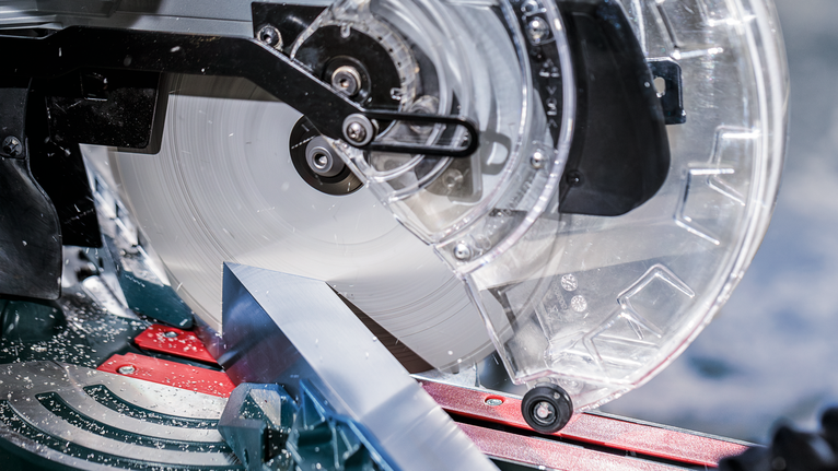 PRO Multi Material Circular Saw Blade, 305 x 3.2 x 30 mm, T80 A metal saw cuts through an aluminum piece in a workshop.