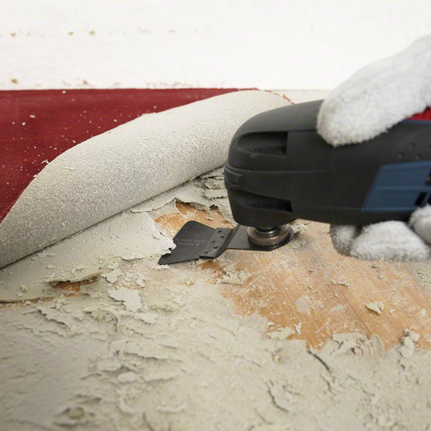 4-piece floor/installation set Person wearing safety equipment uses a multi-tool to remove adhesive under flooring.