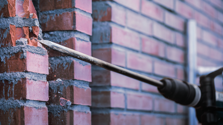 PRO SDS max-4C Pointed Chisel, 300 mm Rotary hammer breaking through a brick wall.