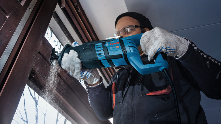 PRO Window Demolition S611DF Blade, 1.25 x 19 x 150 mm, 5 pcs A person wearing safety equipment uses a reciprocating saw to cut a wooden window frame.