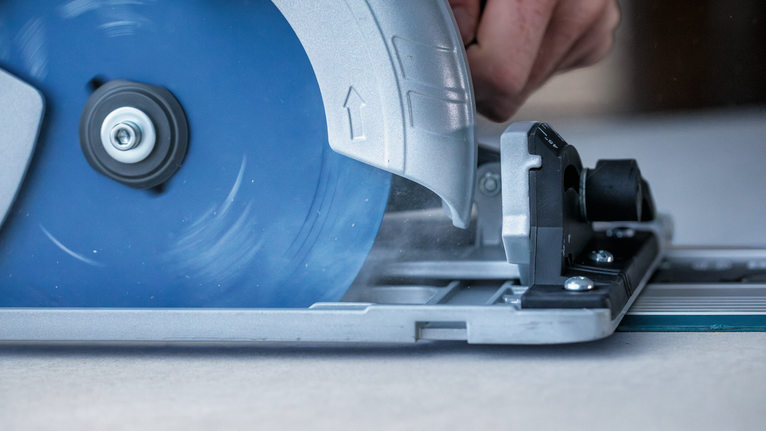 EXPERT Fibre Cement Circular Saw Blade, 165 x 2.2/1.6 x 20 mm, T4 Person operating a circular saw to cut wood along a guide rail.