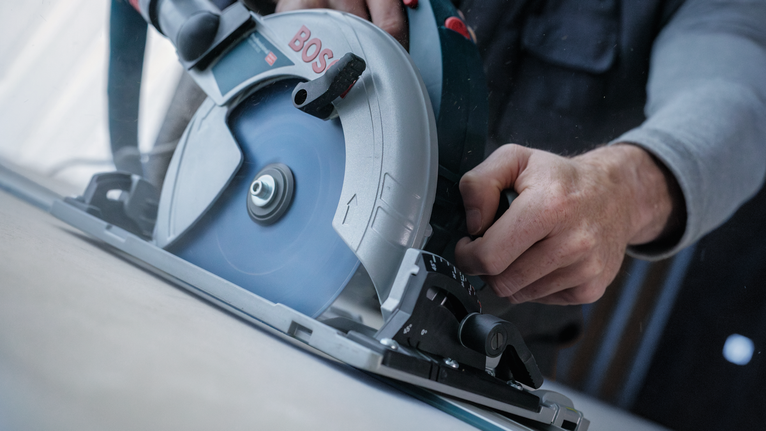 EXPERT Fibre Cement Circular Saw Blade, 165 x 2.2/1.6 x 20 mm, T4 Person operating a circular saw to cut through a wooden board.