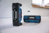 Two rugged blue jobsite radios placed on a construction floor.