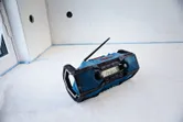 A rugged blue radio sits on the floor of a partially finished room.