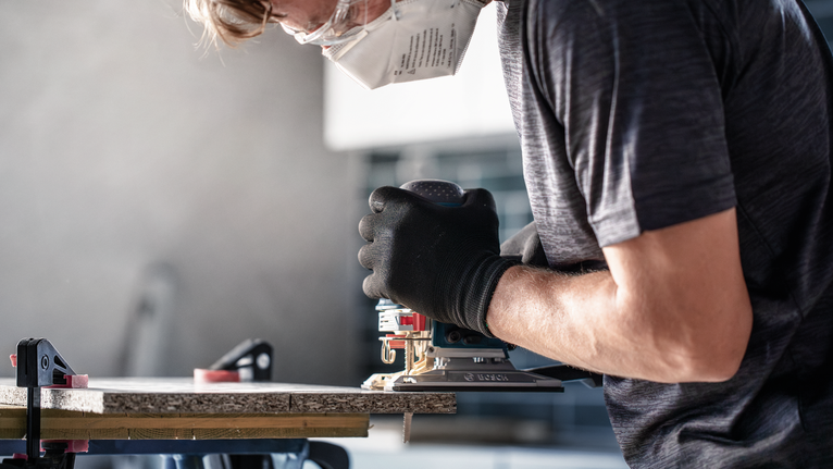 EXPERT ‘Hardwood 2-side clean’ T 308 BF Jigsaw Blade 3-pc Person wearing safety equipment uses a power tool to cut wood.