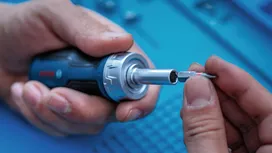 Person inserts a screwdriver bit into a power tool.