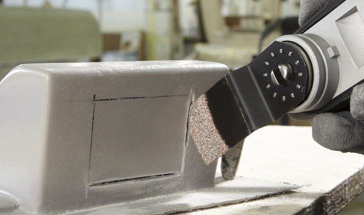 Plunge Cut Saw Blade AIZ 32 RT5 Grout & Abrasive Oscillating tool cuts a precise rectangle in a metal box, worker wearing safety equipment.