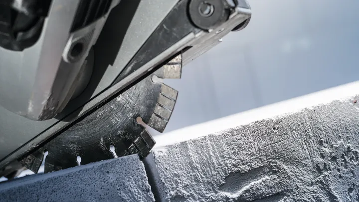 شفرة المنشار الدائرية تقطع كتلة خرسانية.