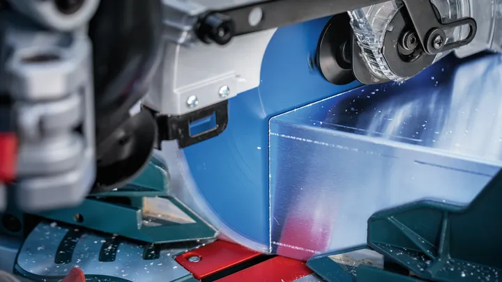 Circular saw blade cutting through a metal workpiece.