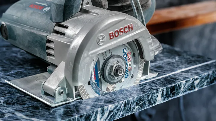 Sierra circular cortando una losa de piedra pulida.