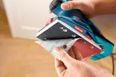 Persona colocando una hoja de papel de lija en una lijadora orbital.