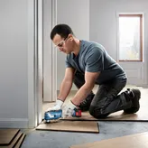 La cortadora múltiple inalámbrica Bosch GOP 185-LI recorta tablas de piso.