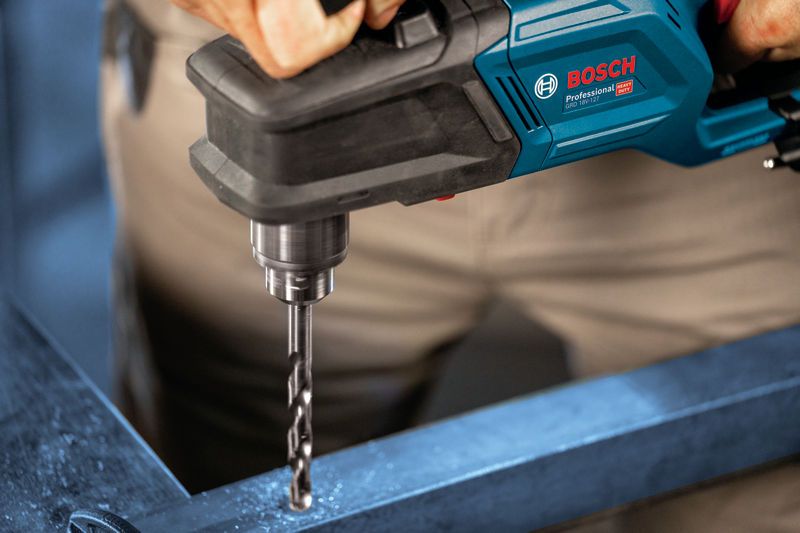 A person drills into metal with a cordless angle drill.