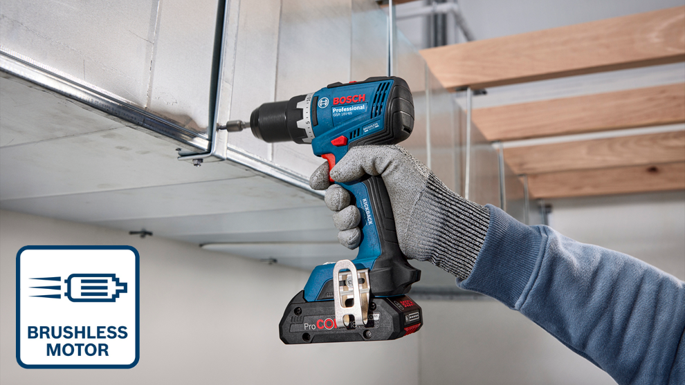 Niebieska wkrętarka Bosch Professional z bezszczotkowym silnikiem trzymana przez osobę w szarej rękawicy. Narzędzie montowane jest do metalowej konstrukcji sufitowej w jasnym pomieszczeniu.