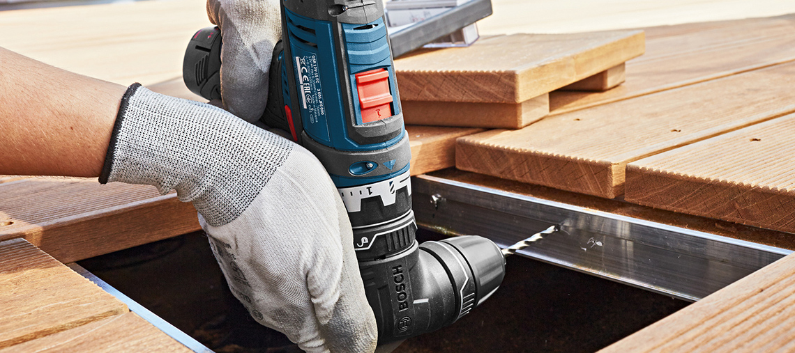 Uma furadeira Bosch Professional sendo usada em tábuas de madeira.