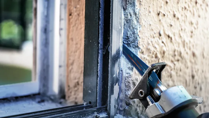 Lâmina de serra alternativa a cortar uma moldura de janela de metal.
