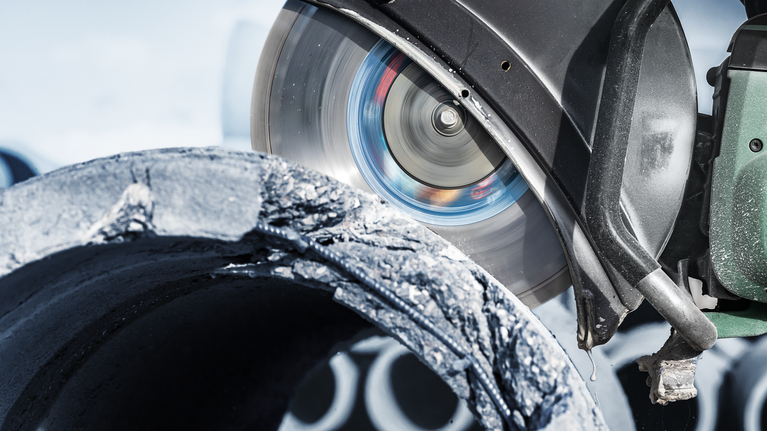 Serra circular a cortar um cano de betão áspero num canteiro de obras.