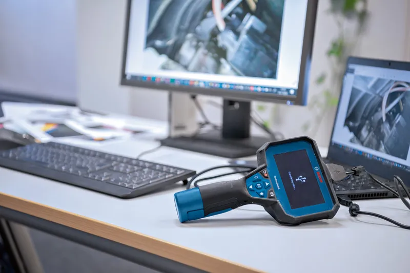 Câmara de inspeção ligada a um computador numa mesa de escritório exibindo imagens do motor.
