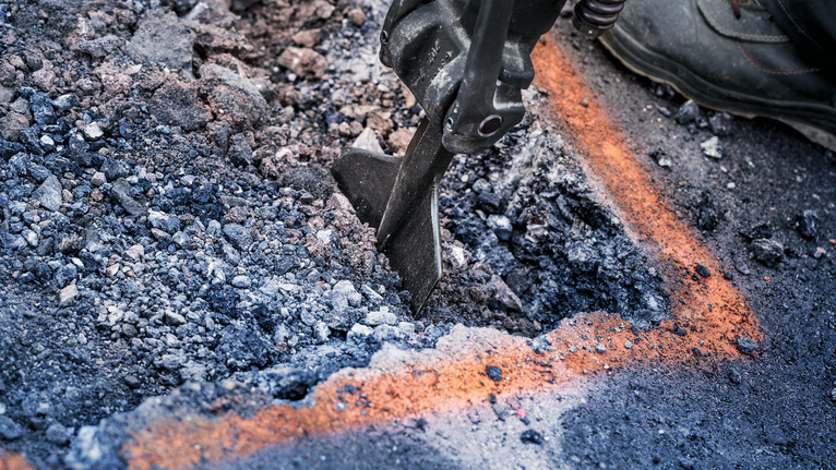 Ferramenta de demolição a partir asfalto dentro das linhas marcadas num estaleiro de obras.