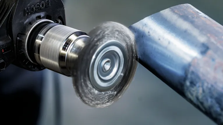 Ferramenta de escova rotativa que polia a superfície de um tubo de metal.