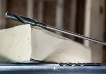 Duas brocas posicionadas perto de um bloco de isolamento de espuma.