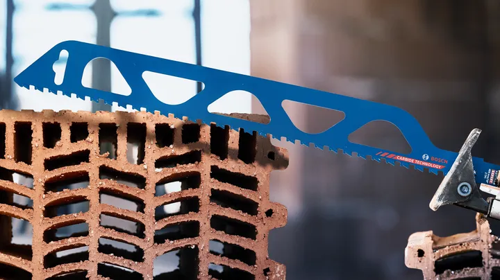 Saw blade cutting through a hollow construction brick.