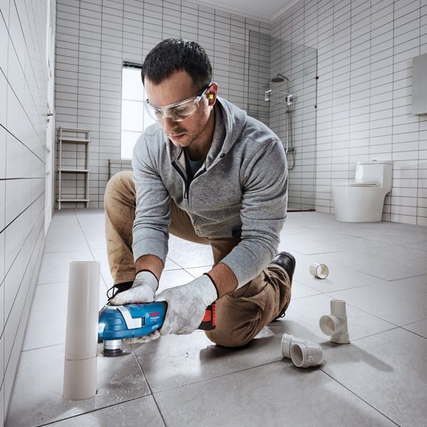 Bosch GOP 185-LI cordless multi-cutter trimming PVC pipe.