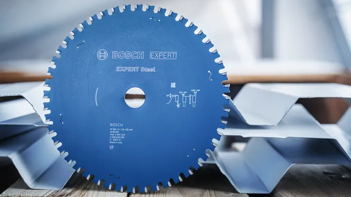Circular saw blade placed upright on corrugated metal sheets.