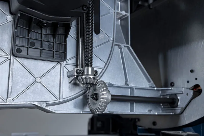 Close-up of a metal gear mechanism inside a table saw base.