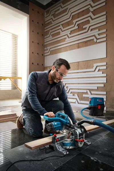Bărbat care folosește un ferăstrău electric cu mitră.