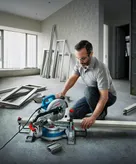 Bărbat care folosește un ferăstrău electric cu mitră.
