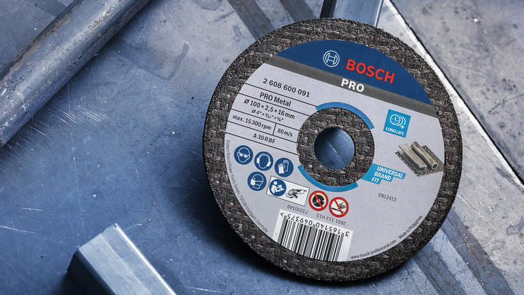Disc de tăiere metalic așezat pe o suprafață metalică într-un atelier.