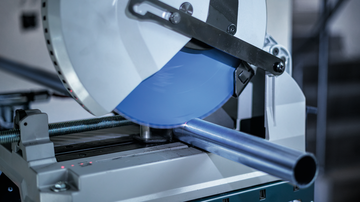 Тестера за сечење метала сече челичну цев у радионици.