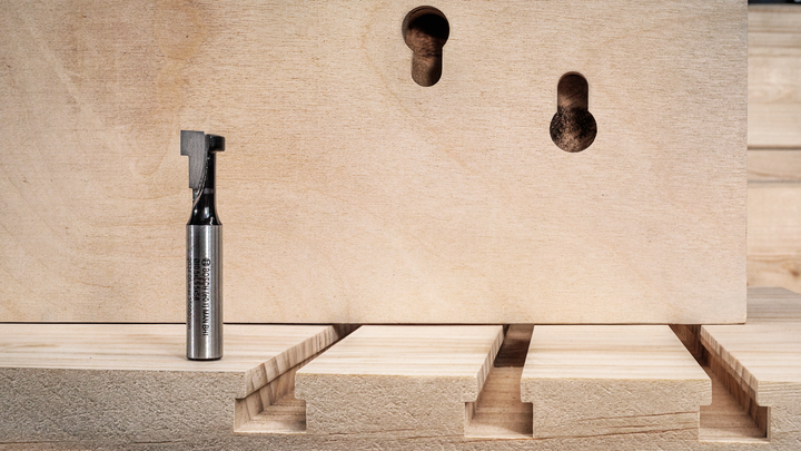 Глодало постављено на дрво, са прецизним жлебовима и прорезима за кључаоницу исеченим на дасци.