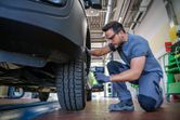 Особа која носи заштитну опрему користи акумулаторски ударни кључ за затезање вијака точкова.