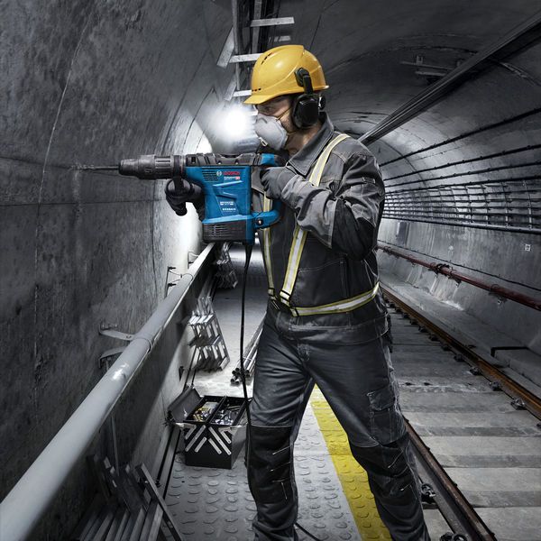 Bosch GBH6-42VB rotary hammer in use on concrete wall.