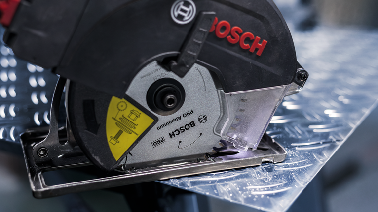 Circular saw cutting through a metal sheet.